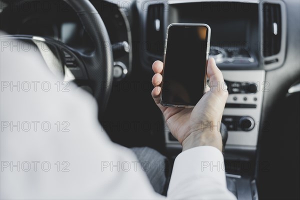 Close up man s hand holding mobile phone with blank screen car