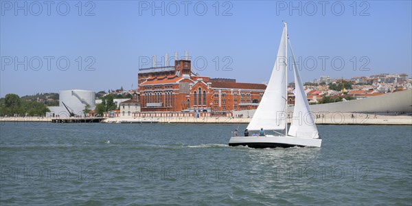 Sailboat navigating in front of the Museum of Electricity