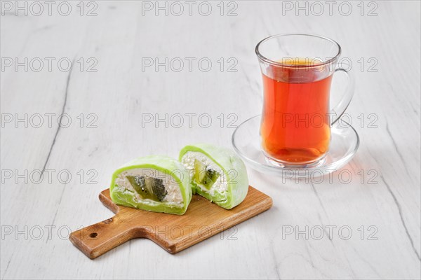 Sweet dessert mochi with kiwi cut on half with fruit tea