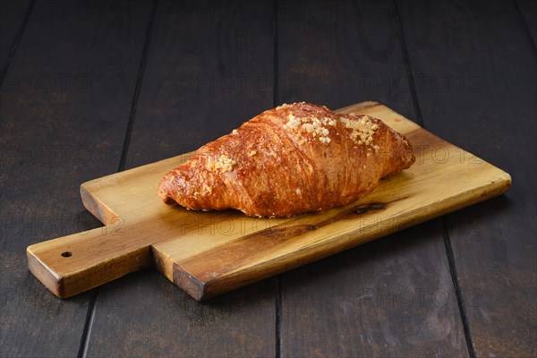 Classic croissant on wooden serving board