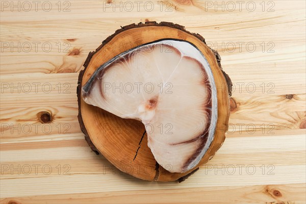 Top view of frozen blue shark steak on wooden table