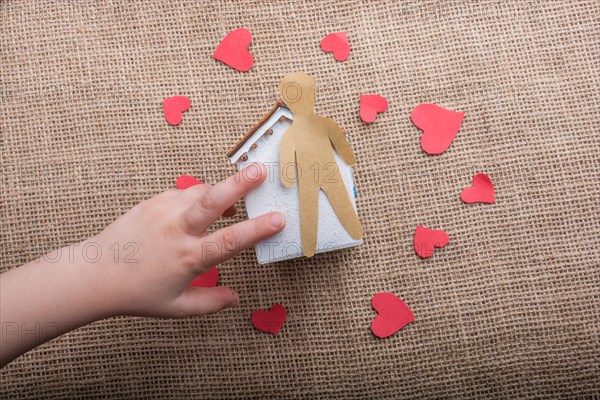 Heart shaped icons and paper house on canvas