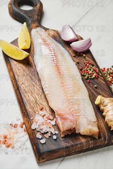 Freshly frozen zander fillet on wooden cutting board