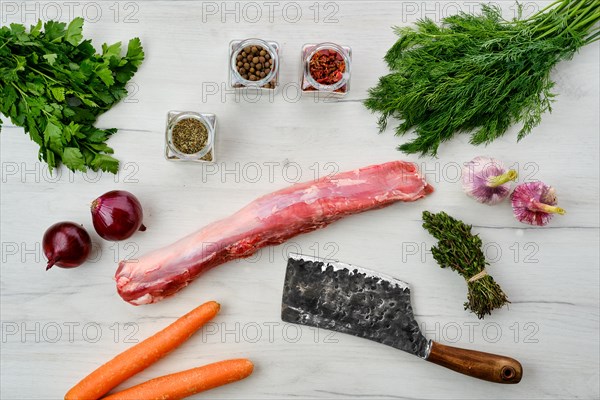 Top view of raw fresh pork fillet with spice on wooden background