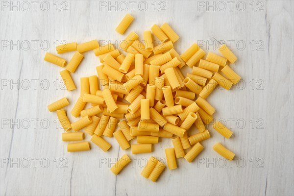 Overhead view of rigatoni pasta on wooden table