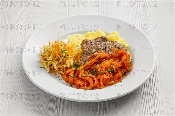 Plate with chopped meat backed with bell pepper with mashed potato and cabbage salad