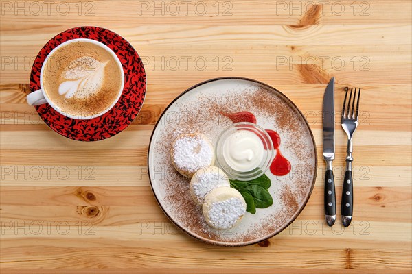 Traditional breakfast with cottage cheese pancake with sour cream