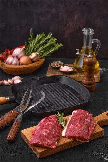 Fresh lamb or veal prime steak on cutting board with herbs