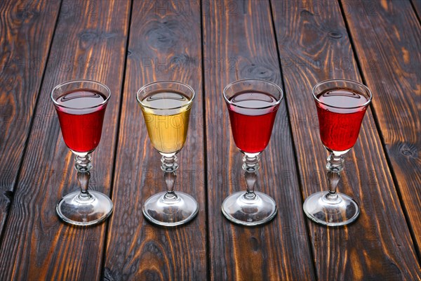 Vodka infused with berries on wooden background