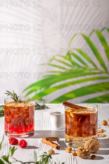 Espresso-tonic refreshing drink with different fruits and syrups on wooden table under morning sun