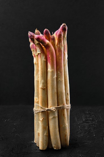 Bunch of asparagus stalks on black background