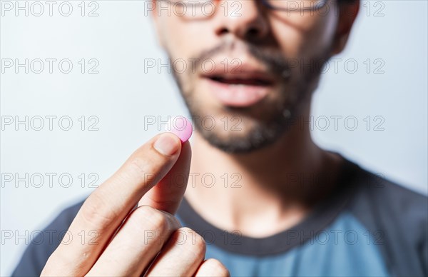 Close up of young man holding aspirine. Self-medication concept