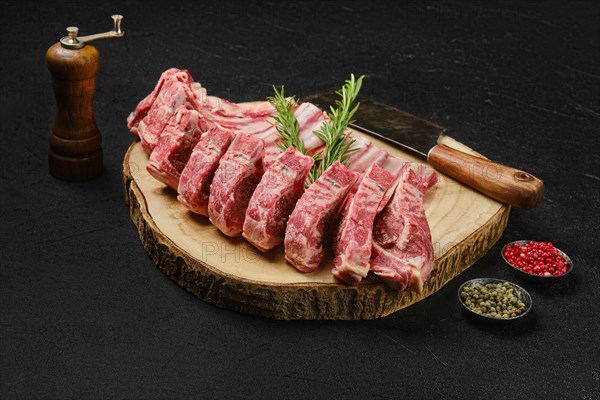 Raw fresh lamb rib roast on wooden slab