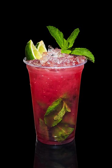 Cold lime and raspberries cocktail with a sparkling wine with ice in take away glass isolated on black