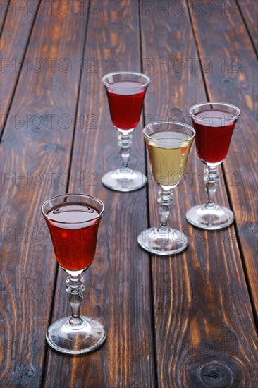 Vodka infused with berries on wooden background