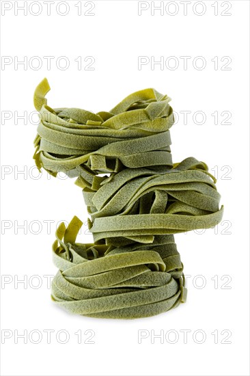 Nest noodles isolated on white background. Italian tagliatelle with spinach