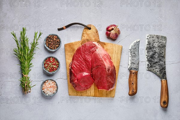 Overhead view of raw fresh deer boneless ham with spice and herb over concrete background