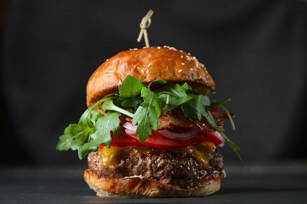 Close-up photo if burger on black background with cheese