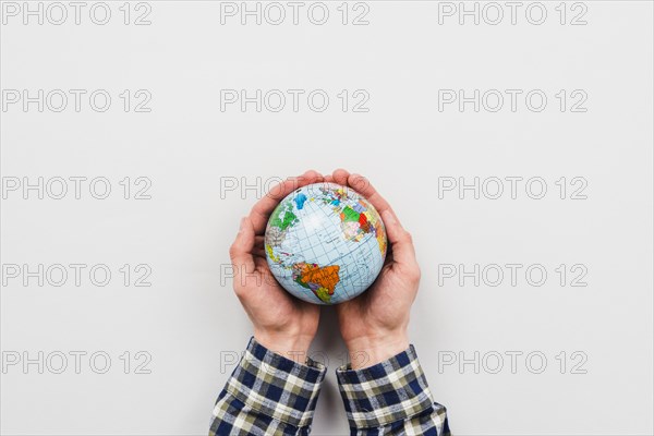 Earth globe hands grey background