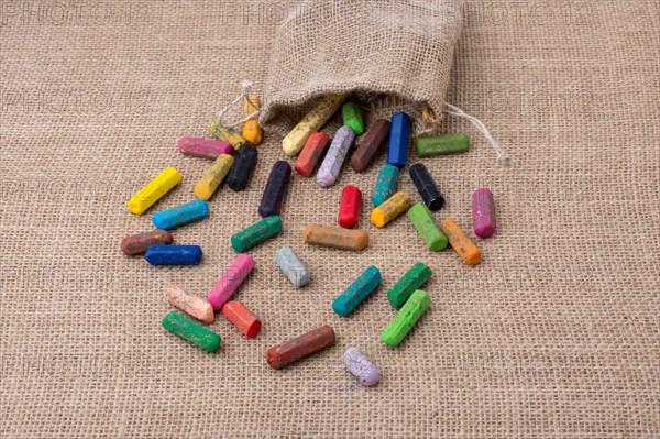 Crayons of various color out of a sack on a canvas