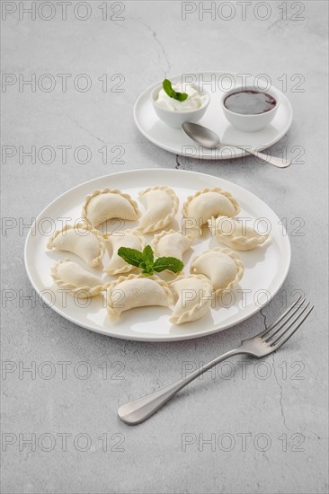 Frozen semifinished vareniki stuffed with cherry on grey background