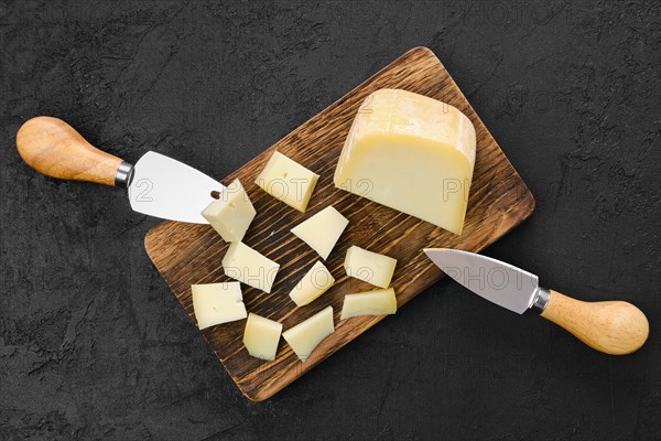 Top view of goat cheese cut on pieces on wooden cutting board