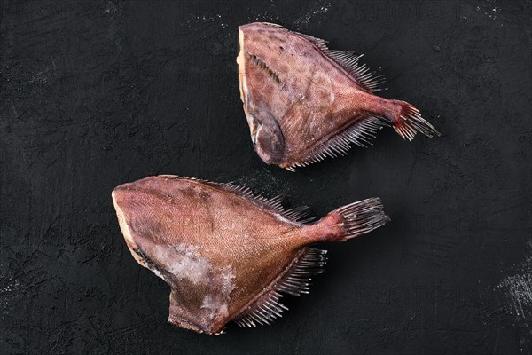 Raw frozen crimson sea bream on black background