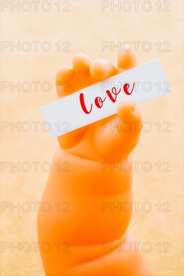 Toy doll hand holding paper with LOVE wording