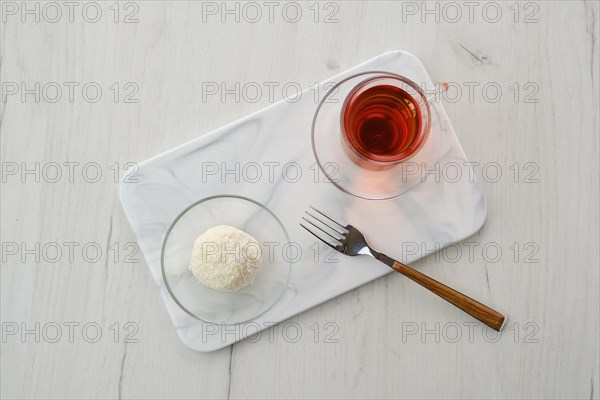 Top view of coconut biscuit dough cake and a cup of tea on a table