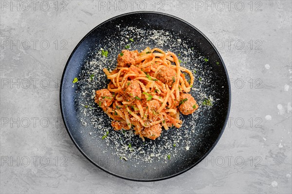 Top view of spaghetti pasta with meatballs and grated cheese