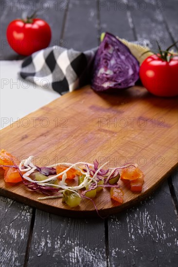 Fresh vegetables on wooden board with a napkin on a table