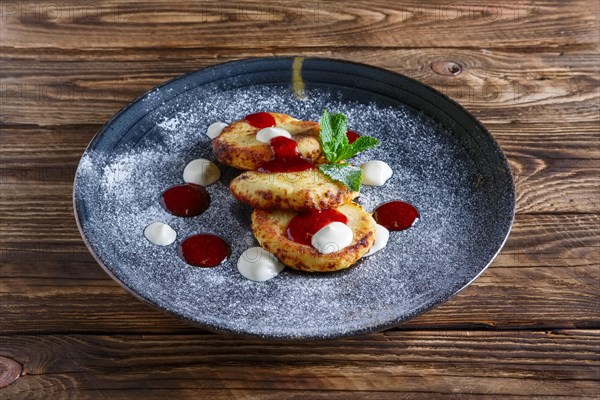 Cheese pancakes served with sour cream and strawberry jam