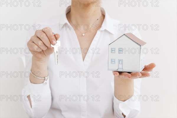 Woman holding key small paper house white background. Resolution and high quality beautiful photo