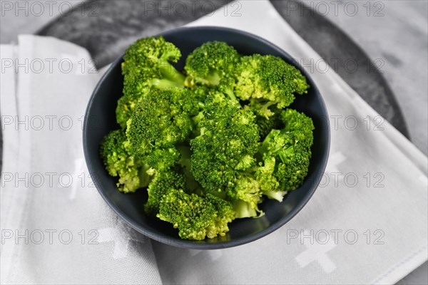 Top view of healthy steamed broccoli vegetables in dark bowl