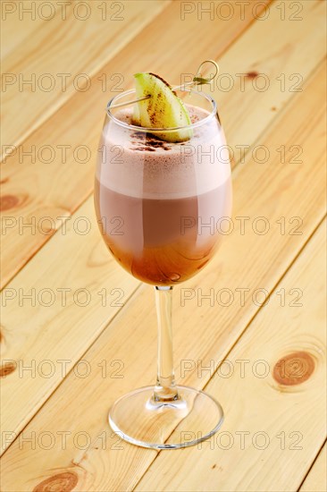 Latte macchiato with apple in transparent glass on wooden background