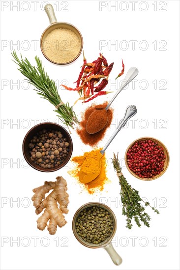 Composition with seasonings and herbs in bowls and spoons isolated on white background