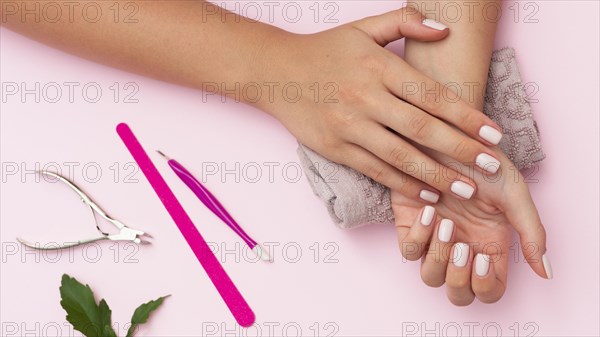 Hands with manicure done and nail care tools