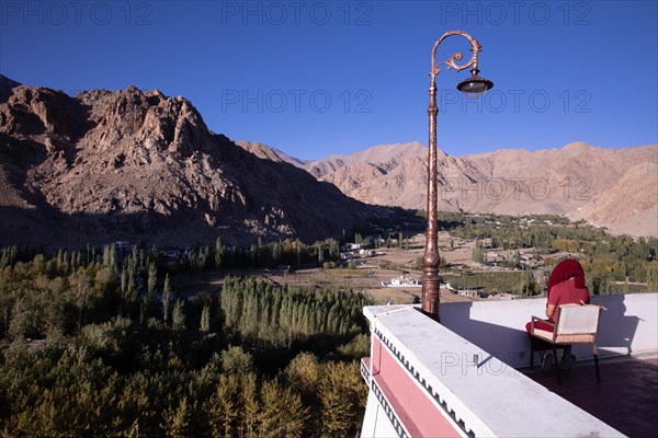 Monk looking out on the fields surrounding Matho Monastery