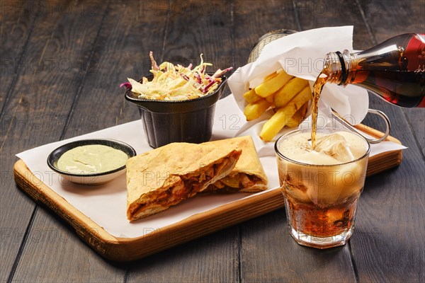 Pouring cola in a glass. Fast food snack concept