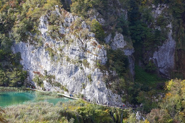 Hikers on wooden footbridge in Plitvice Lakes National Park