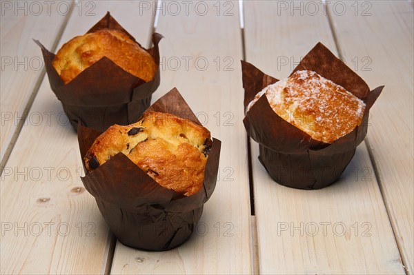 Fresh muffins on wooden table. Selective focus photo
