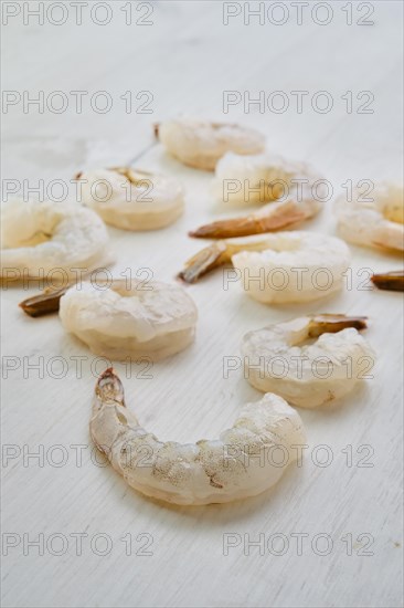 Peeled fresh raw white prawns on wooden background