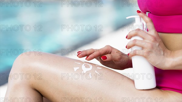 Close up view woman using sunscreen