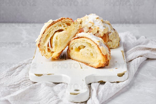 Croissant with caramel and peanut shavings cut in half on marble background