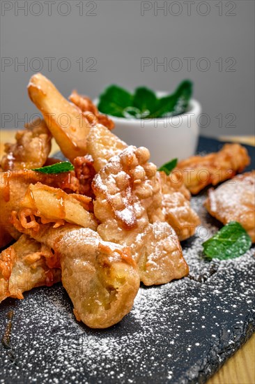 Close up view of deep fried fruits in breading served with caramel and strawberry jam