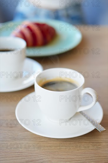 Hot coffee and croissant on background