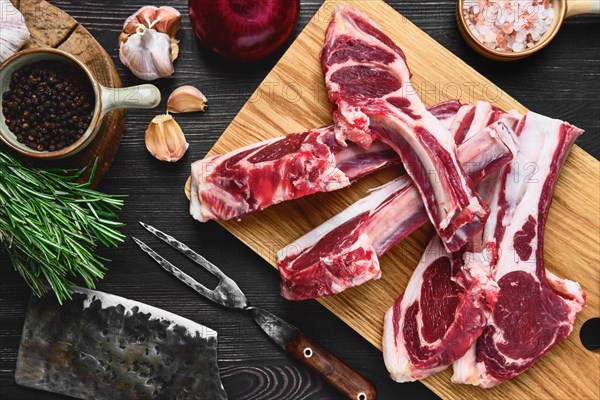 Top view of raw lamb rib chops on wooden cutting board