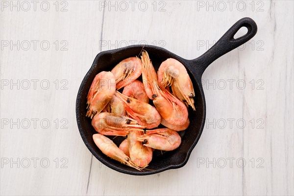 Top view of cast iron skillet with steamed unpeeled shrimps