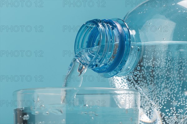 Pouring sparkling water in cup