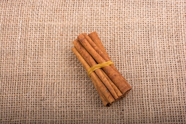 Bundle of cinnamon sticks on a linen canvas background